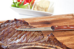 Cooked beef steak on cutting board.