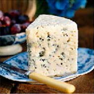 photo of wedge of blue cheese on blue plate with bone handle knife