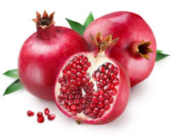 photo of whole and halved pomegranates